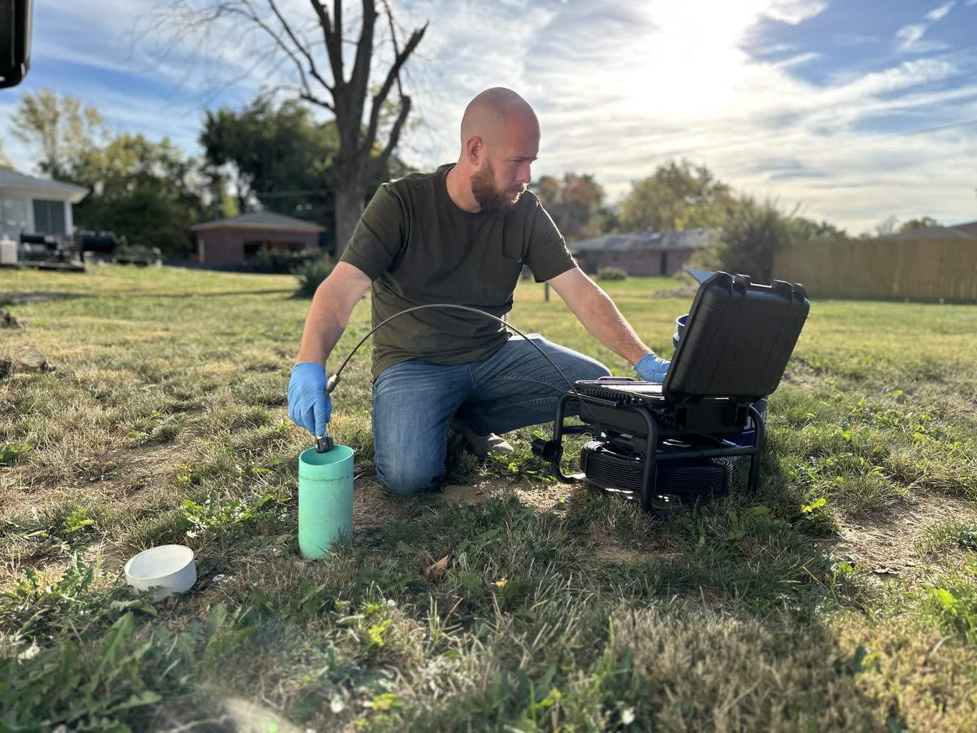 Operator at a yard cleanout opening the camera monitor case.