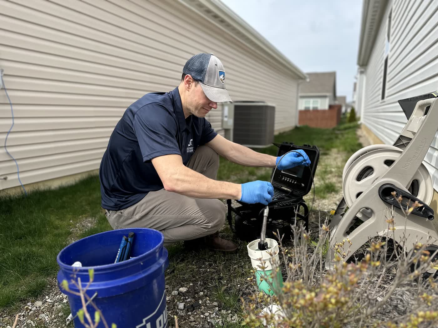 Sewer Scope inspector running a residential scope at a side-yard cleanout.