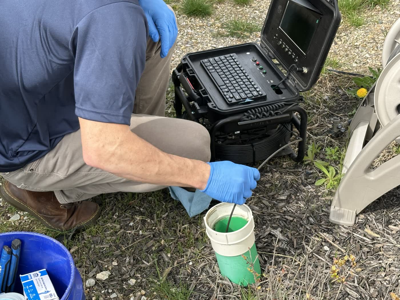 Inspector cleaning the camera cable line during a residential sewer inspection.